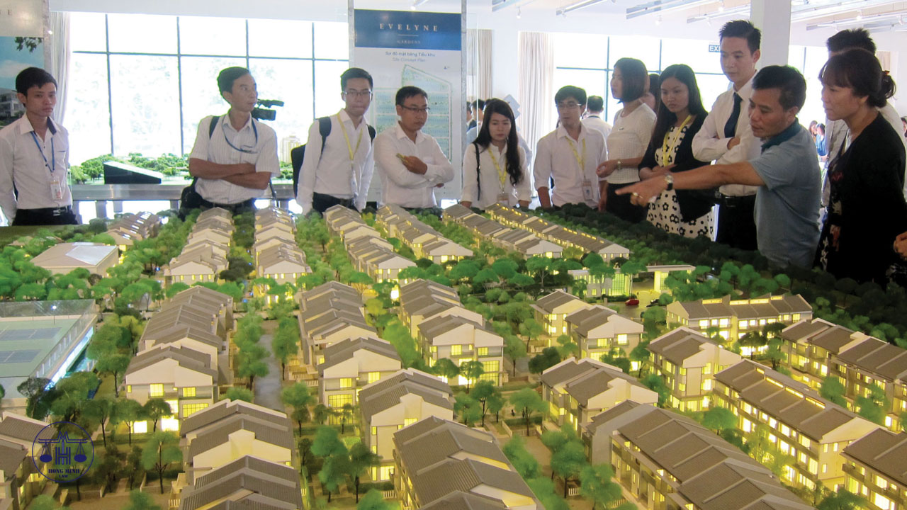 Dự án nhà ở hình thành trong tương lai cần thỏa mãn các điều kiện để được mua bán một nhóm người đang đứng xem xét và thảo luận về mô hình dự án nhà ở hình thành trong tương lai