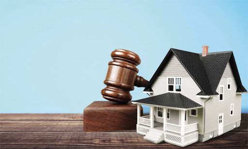 mô hình ngôi nhà được đặt bên trên cuốn sách luật